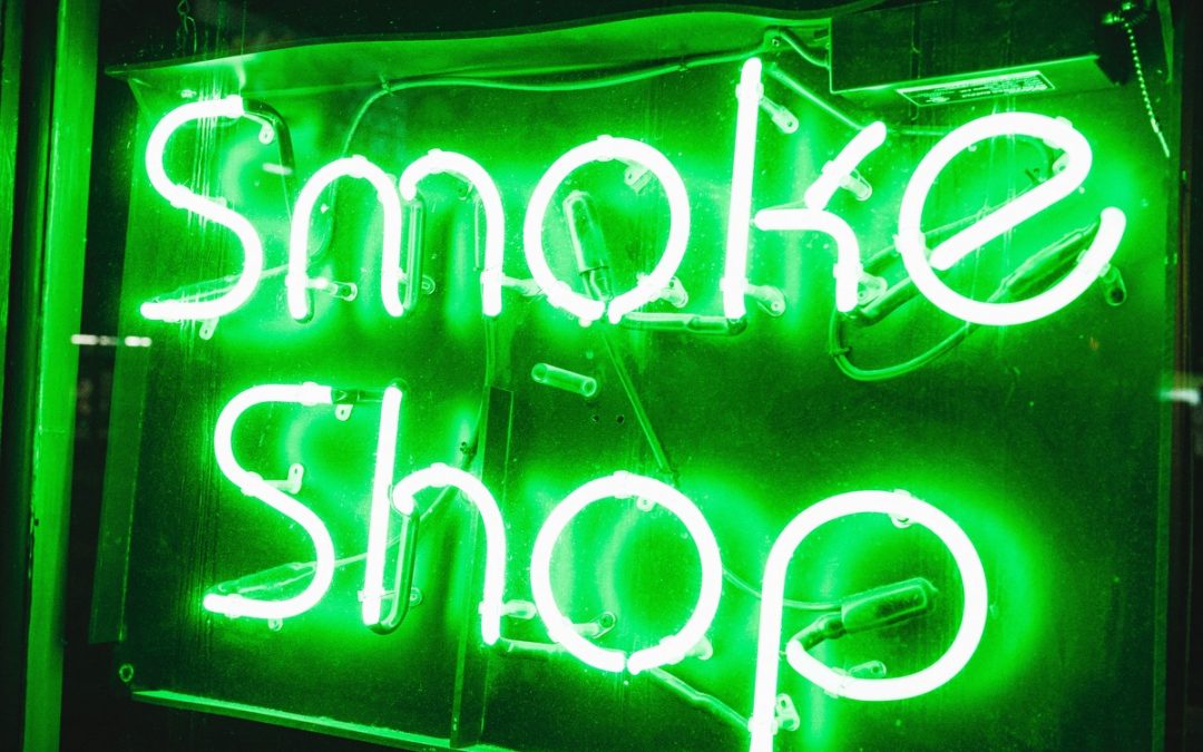 Green neon smoke shop sign at a successful business that uses tobacco store point of sale